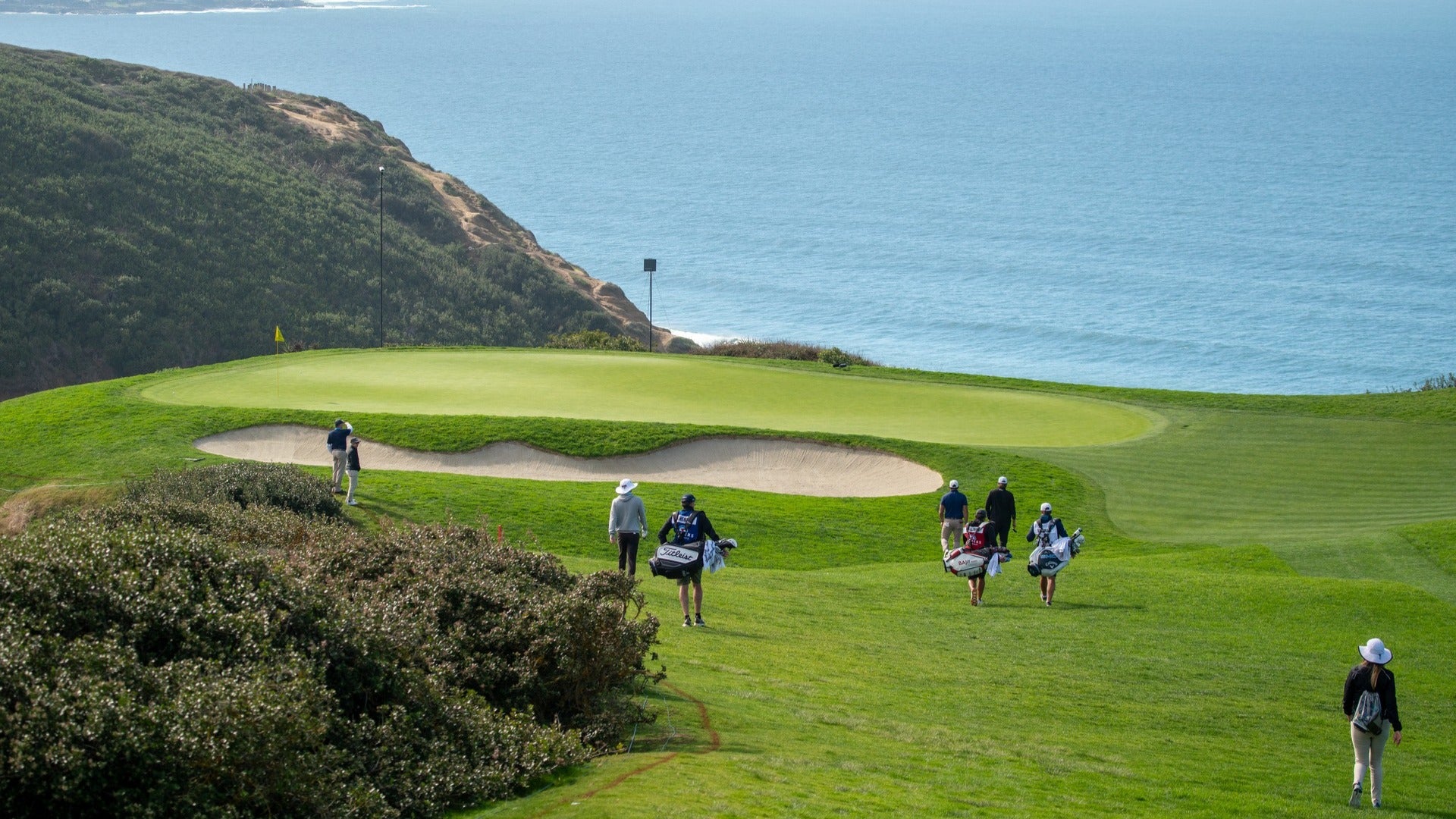 people on a golf course with view of the sea